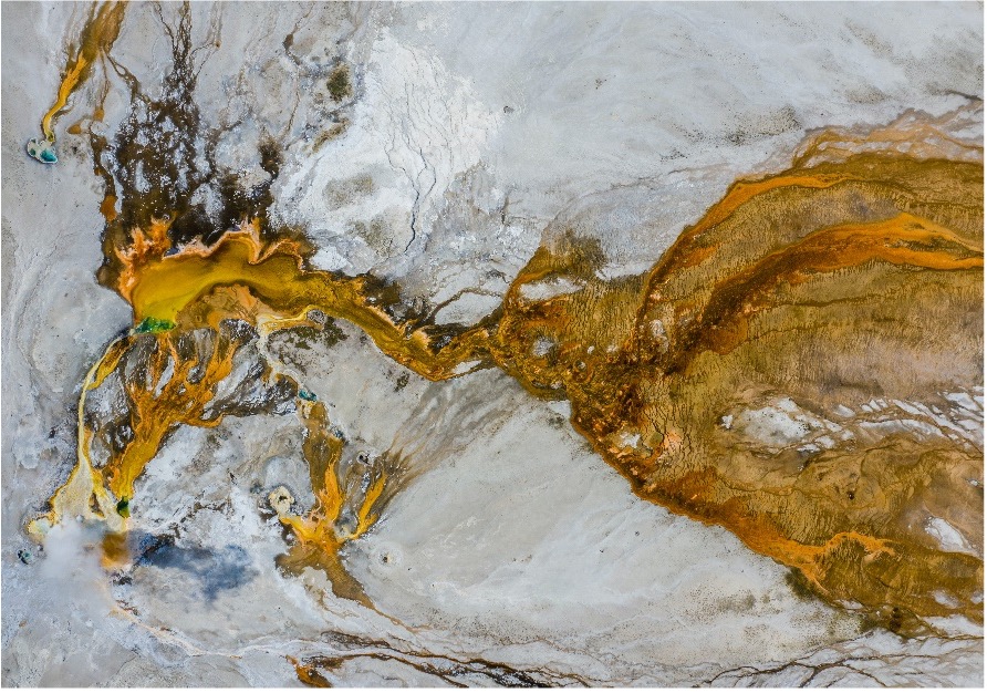 a view of yellow, brown, and white mineral and rock formations from the air above the earth's surface